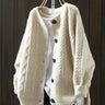 Front view of oversized cable knit cardigan with button-down front and ribbed hem