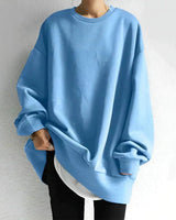 Model wearing oversized crewneck jumper styled with slim-fit trousers