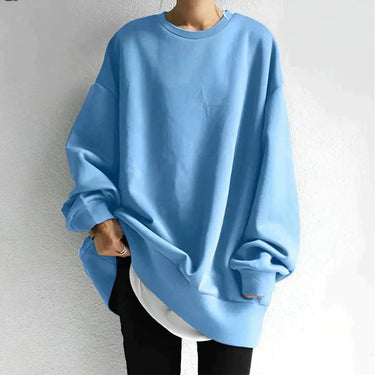 Model wearing oversized crewneck jumper styled with slim-fit trousers