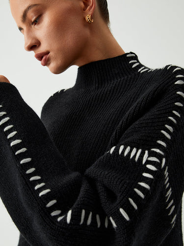 Side view showing dropped shoulders and hip-length hem of the knit jumper