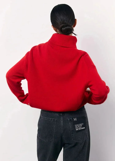 Close-up of the roll neck collar detail on the red sweater
