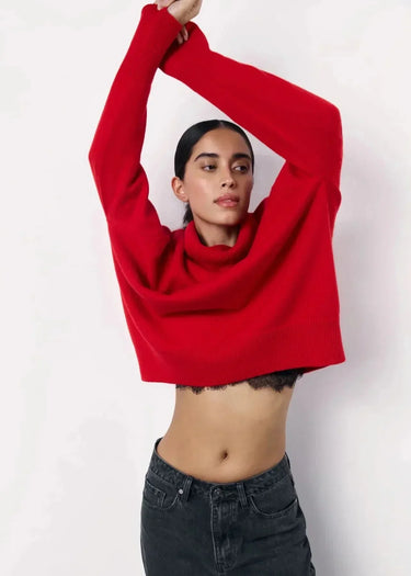 Full-length view of the red turtleneck sweater styled with trousers