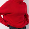 Red oversized roll neck sweater shown from a three-quarter angle