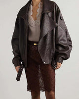 Side view showing drop shoulders and belted hem of a leather bomber jacket