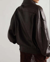 Close-up of asymmetric zip and snap button closure on a leather bomber jacket