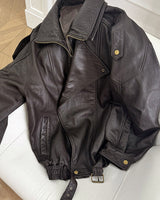 Back view of an oversized leather bomber jacket with structured seams