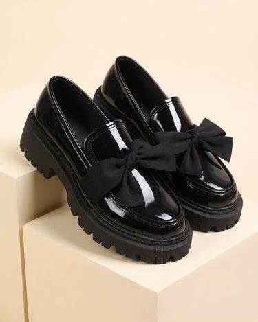 Patent loafer with grosgrain bow and chunky lug sole, front three-quarter view