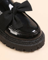 Heel view of patent loafer showing sole height and upper finish