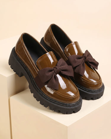 Side profile of patent loafer showing bow detail and thick rubber sole