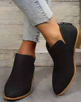Ankle boots styled with straight-leg trousers, front three-quarter view