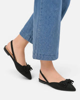 Pair of pointed toe slingback flats on a plain background
