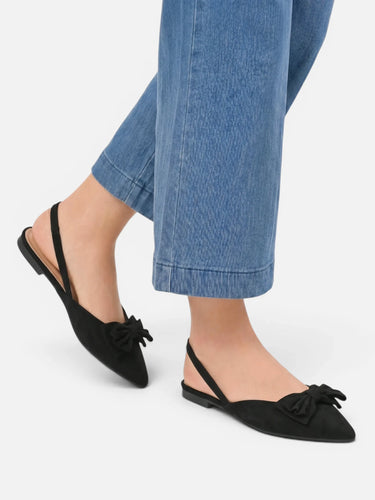 Pair of pointed toe slingback flats on a plain background