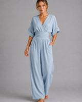 Side view showing the relaxed silhouette and wide-leg fit of the denim jumpsuit