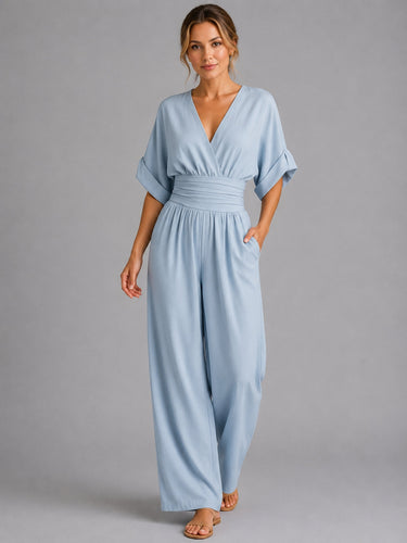 Side view showing the relaxed silhouette and wide-leg fit of the denim jumpsuit