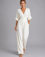 Front view of a wide-leg denim jumpsuit with V-neckline and cinched waist