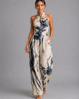 Front view of a wide-leg halter jumpsuit in light blue with an all-over print