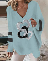 Detail view of heart print fabric on a relaxed fit long sleeve V-neck top