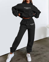 Front view of women's two-piece jogging set in black, showing relaxed-fit top and matching trousers
