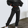 Front view of women's two-piece jogging set in black, showing relaxed-fit top and matching trousers