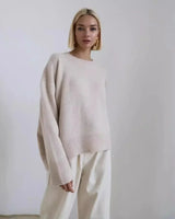 Side view of a relaxed-fit long-sleeve sweater showing hip-length hem