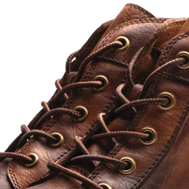 Men's leather boot styled in a street setting, three-quarter view