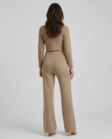 Side view showing the wide-leg trouser silhouette and fitted long-sleeve top