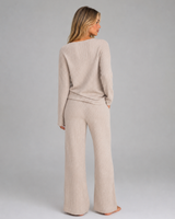 Side view showing the wide leg silhouette of the ribbed knit trousers