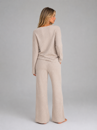 Side view showing the wide leg silhouette of the ribbed knit trousers