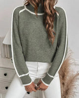 Side view showing the hip length and long sleeve silhouette of the sweater