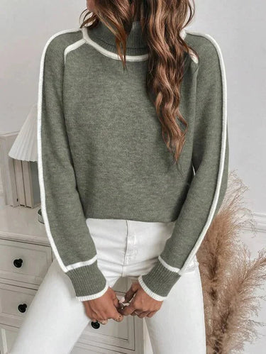 Side view showing the hip length and long sleeve silhouette of the sweater