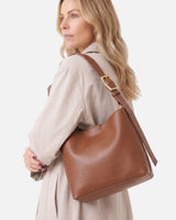 Model wearing the hobo bag over one shoulder against a neutral background