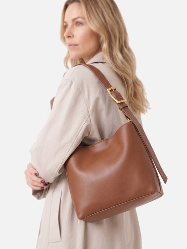 Model wearing the hobo bag over one shoulder against a neutral background