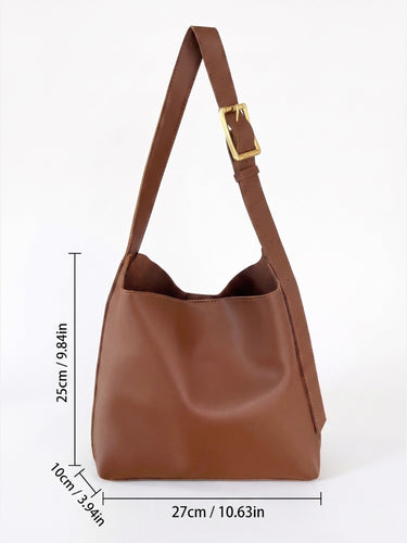 Flat lay of the hobo bag next to everyday essentials such as a phone and wallet