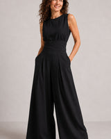 Model wearing sleeveless wide-leg jumpsuit in graphite, styled for a casual occasion
