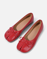 Top-down view of split-toe ballet flat on plain background