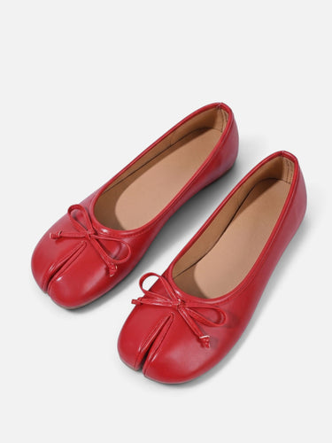 Top-down view of split-toe ballet flat on plain background