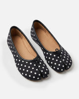 Side profile of polka-dot ballet flat showing flat sole and split toe