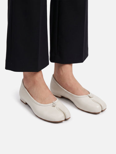 Pair of leather split-toe ballet flats on a plain background