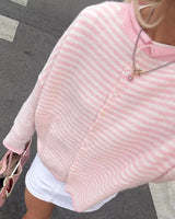 Detail shot of button-front closure on striped knit cardigan