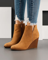 Suede ankle boots with stacked wedge heel and side cut-out at topline, front view