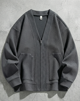 Close-up of V-neck and front zip detail on textured men's cardigan