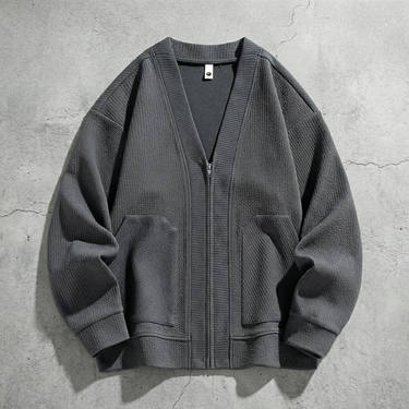 Close-up of V-neck and front zip detail on textured men's cardigan
