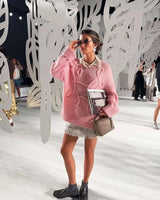 Back view of the pink textured knit sweater showing ribbed hem and relaxed fit