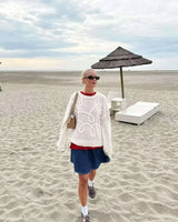 Side view of the pink knit sweater showing hip length and sleeve detail