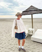 Front view of the white textured knit sweater with long sleeves and ribbed cuffs
