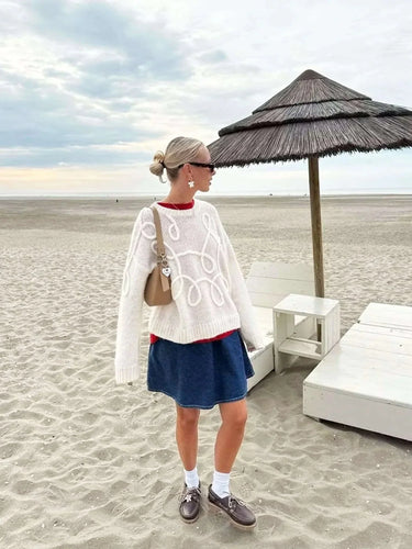 Front view of the white textured knit sweater with long sleeves and ribbed cuffs