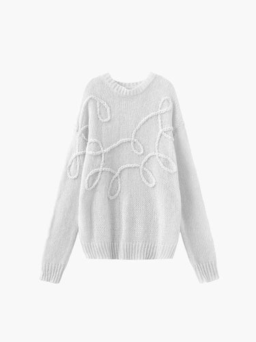 Detail shot of the ribbed cuff and sleeve on the white knit sweater