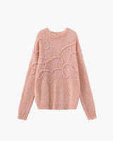 Front view of a pink textured knit sweater with long sleeves and ribbed cuffs