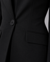 Close-up of the collarless blazer front and structured shoulder detail