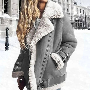 Close-up of buckle-strap cuffs and belted hem detail on faux leather moto jacket